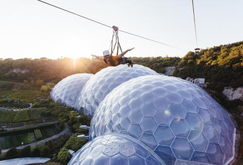 Person on zip wire over Eden Project